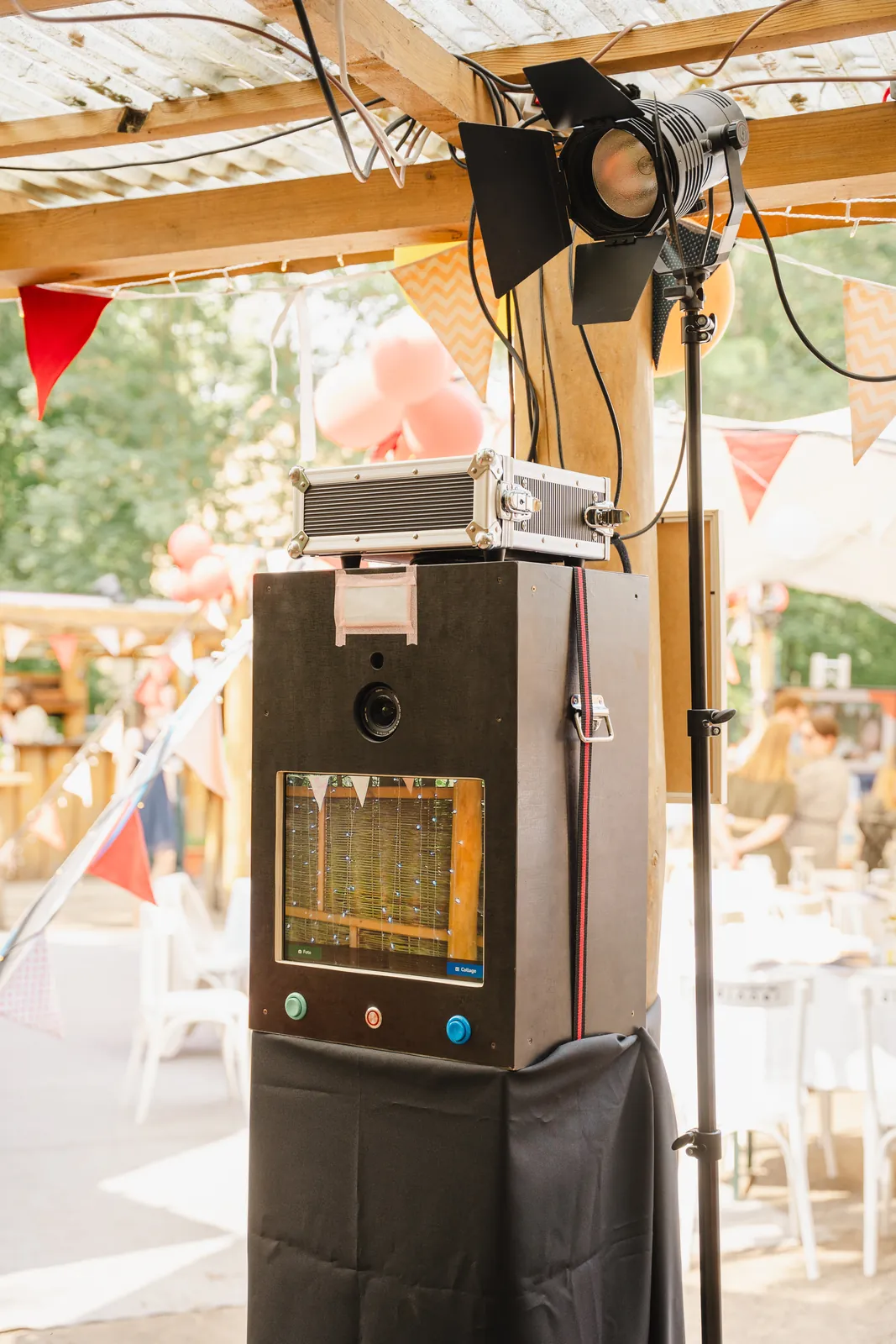 Die Fotobox im Einsatz auf einer Hochzeit, beleuchtet von einem Scheinwerfer